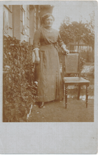 Mladá žena s květinou u židle (pohled)
